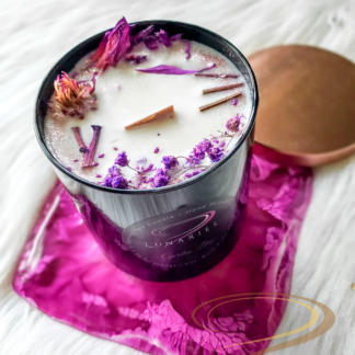 Garden Lilac soy candle in a black glossy tumbler jar, featuring a wooden wick and decorated with vibrant purple botanicals and lilac-inspired purple dried flowers.